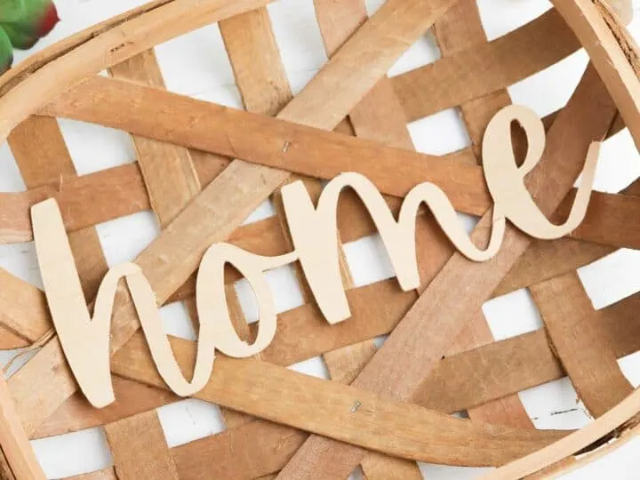 wooden sign of word home displayed in decorative basket