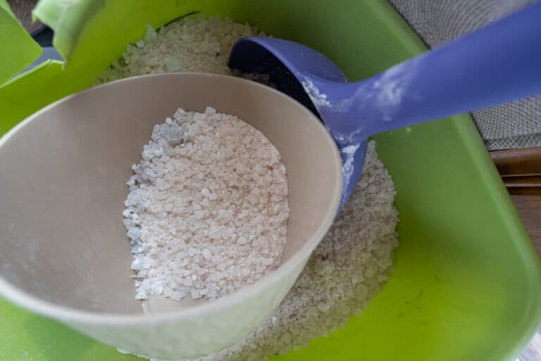 rock salt in a bucket is ready to scoop and melt ice on your wintery sidewalk