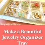 handmade jewelry organizer tray on pink dresser next to green plant