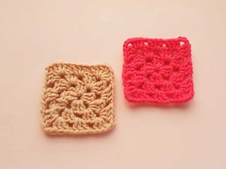 two crocheted granny squares on peach colored background