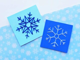 hand sewn snowflake patterns on blue pieces of paper