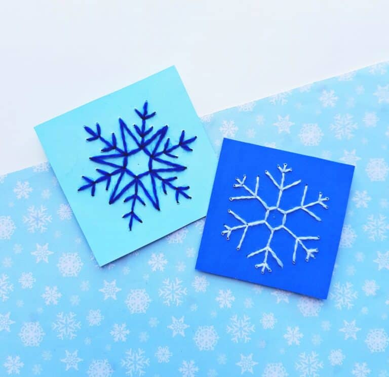 hand sewn snowflake patterns on blue pieces of paper