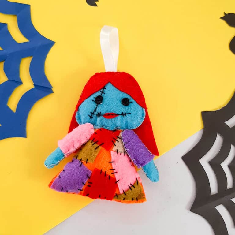 DIY sally plushie made out of felt laying on yellow background