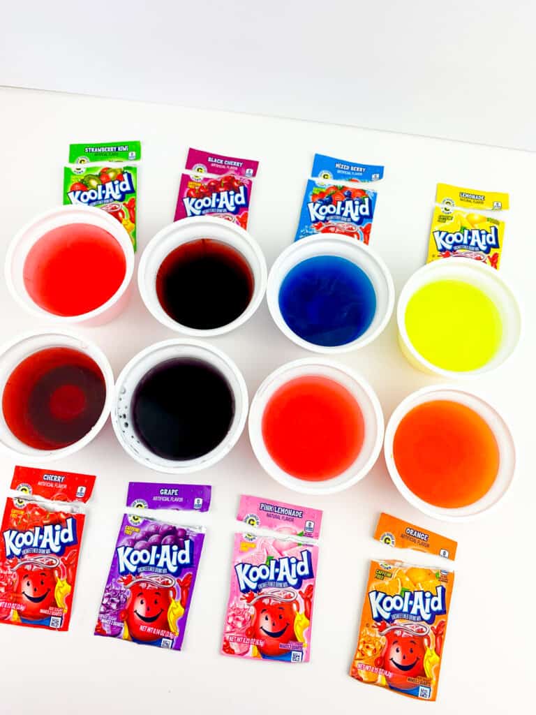 kool aid pouches next to cups of dyes