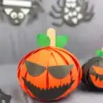 paper strip pumpkin craft in front of Halloween background