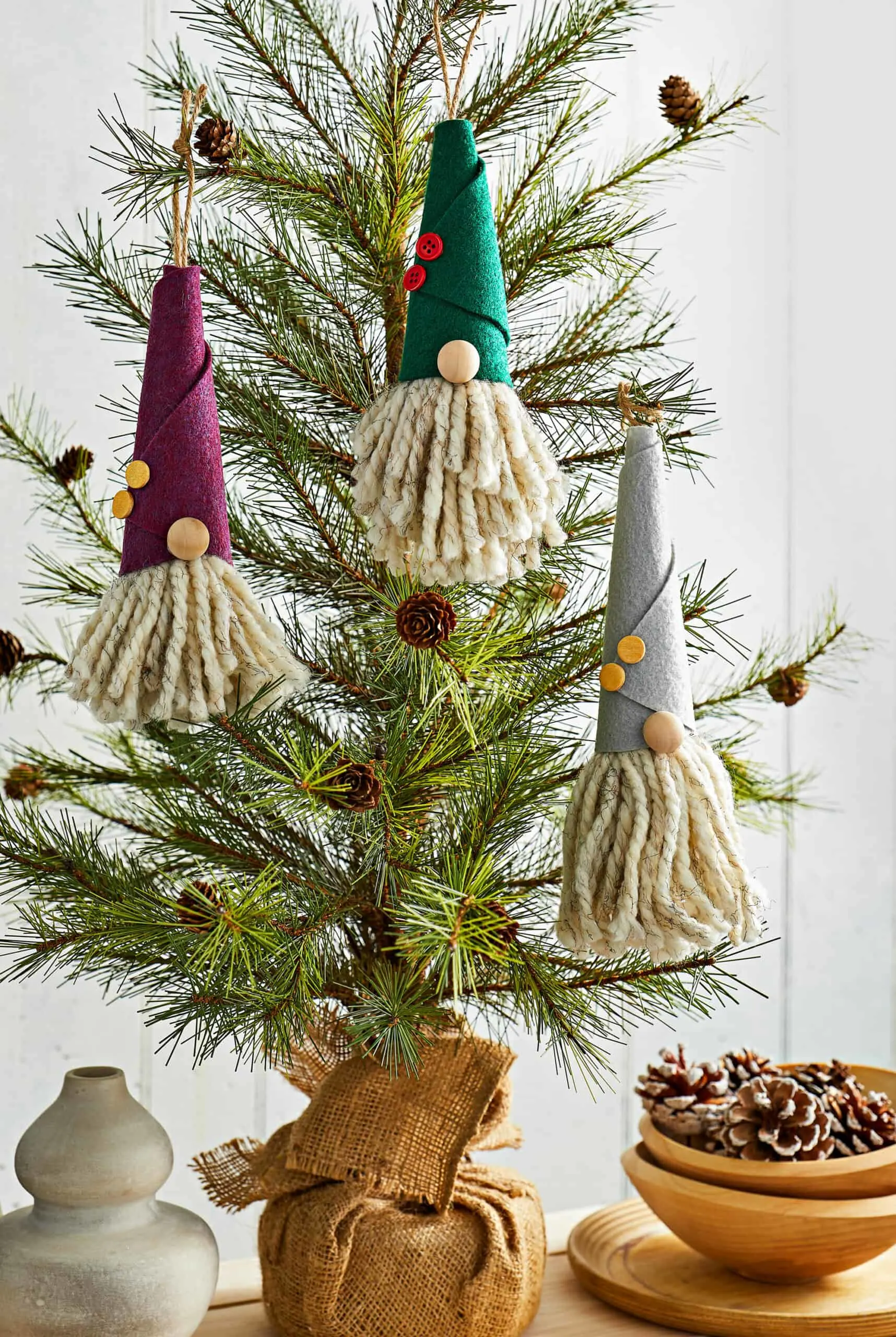 three cute handmade gnome ornaments hanging in Christmas tree