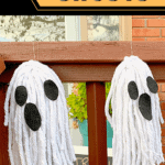 two mop ghosts hanging from porch railing