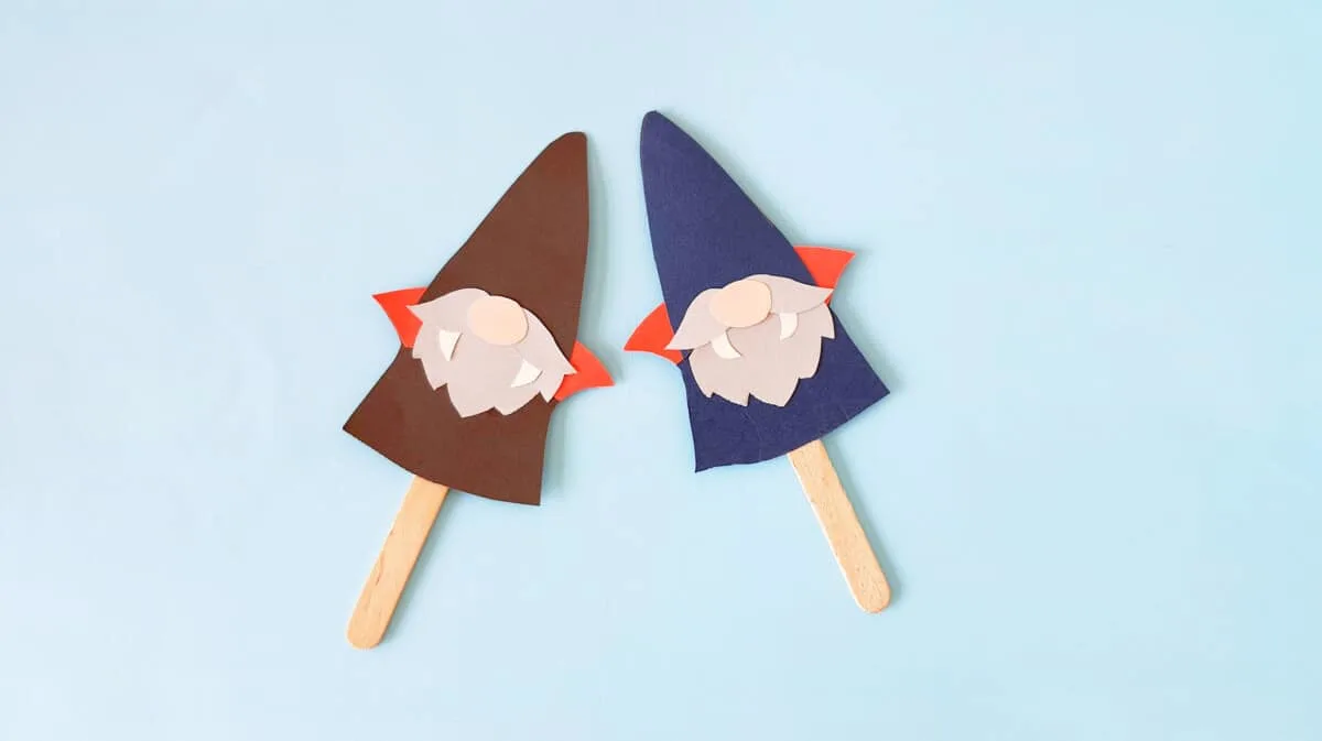 two handmade vampire gnomes laying flat on blue background