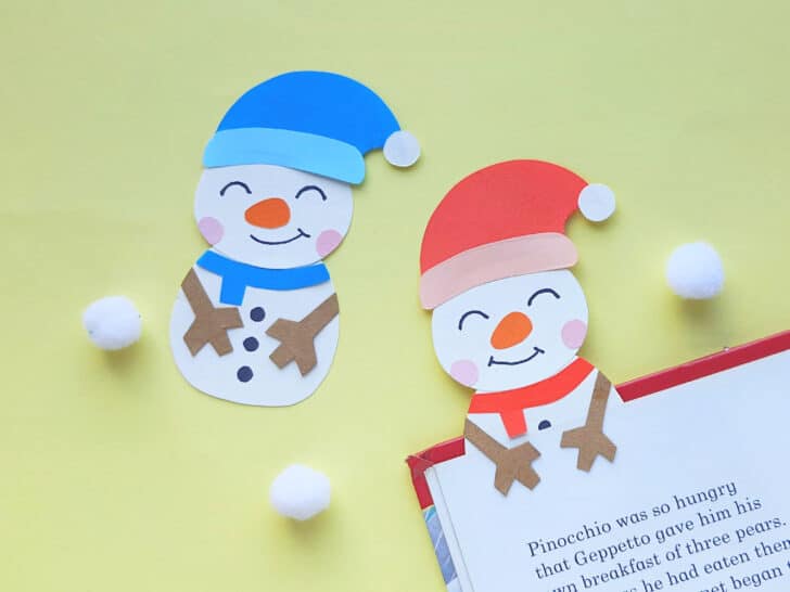 two paper snowman books made from free pattern on a book against a yellow background
