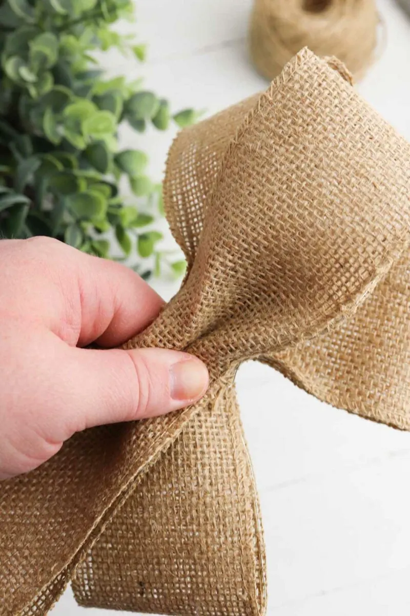 burlap ribbon bow loops pinched together with fingers
