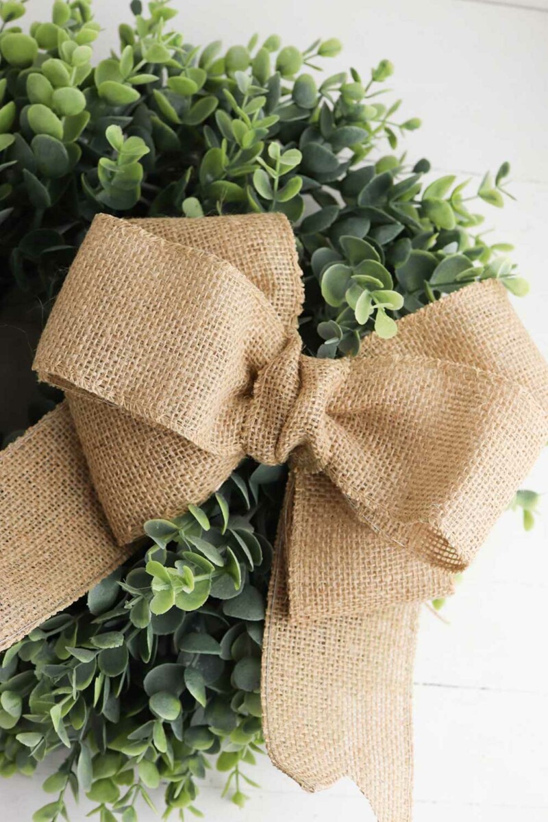 Wreath that has a burlap bow on it