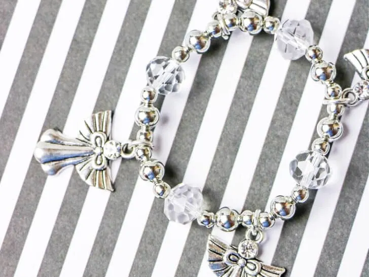 handmade angel bracelet on grey and white striped background
