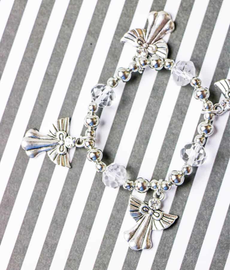 handmade angel bracelet on grey and white striped background