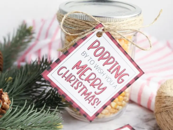 free printable popcorn gift tag on mason jar of kernels with greenery in background