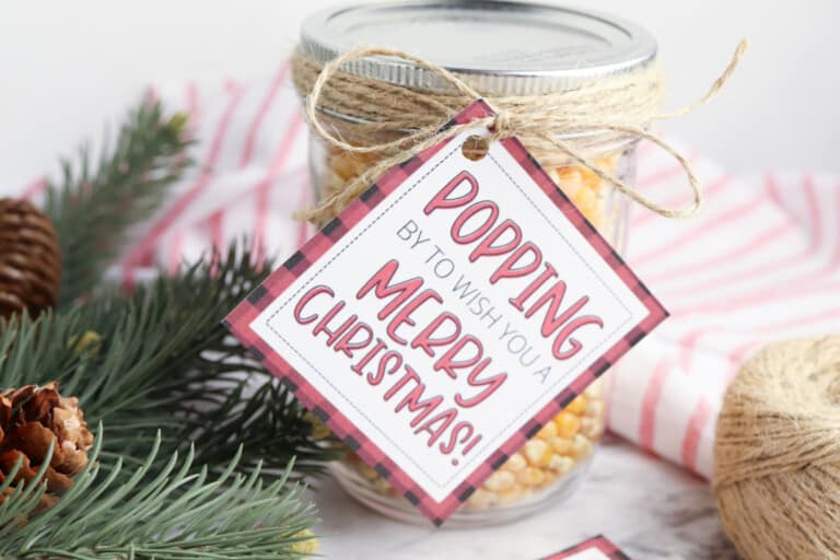 free printable popcorn gift tag on mason jar of kernels with greenery in background