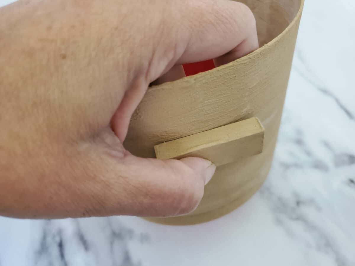 Glueing painted tumble blocks to the side of plastic painted flower pot.