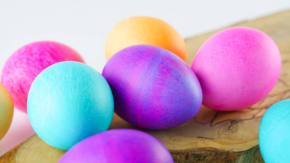 brightly colored eggs on a wooden board