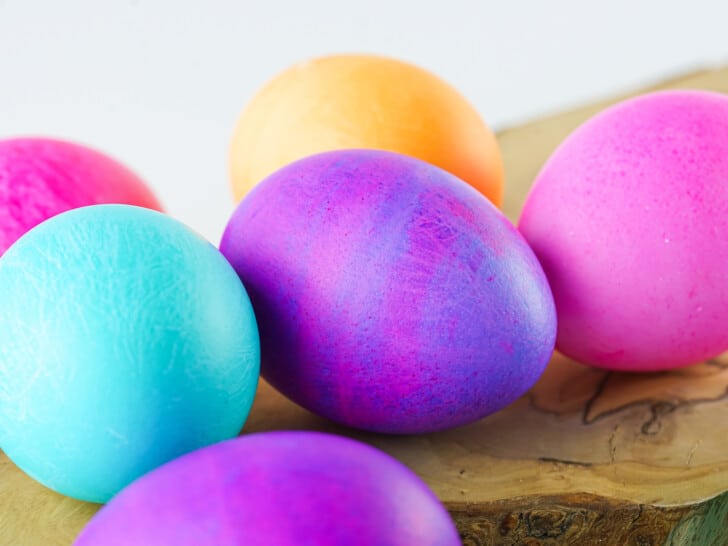 brightly colored eggs on a wooden board