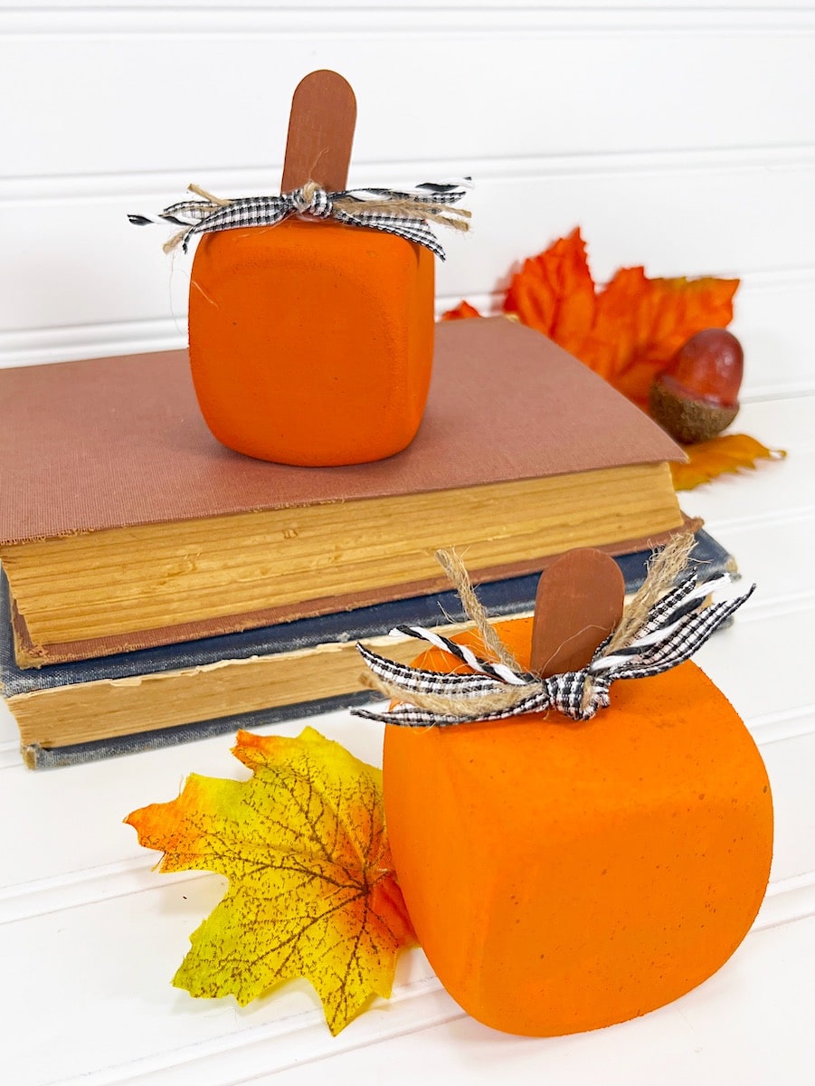 Foam Dice Pumpkin with Fall Leaves and Books on white wood background