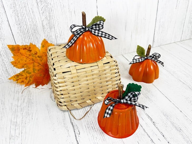 Tin Mold Pumpkins on Straw Basket against white wood wall