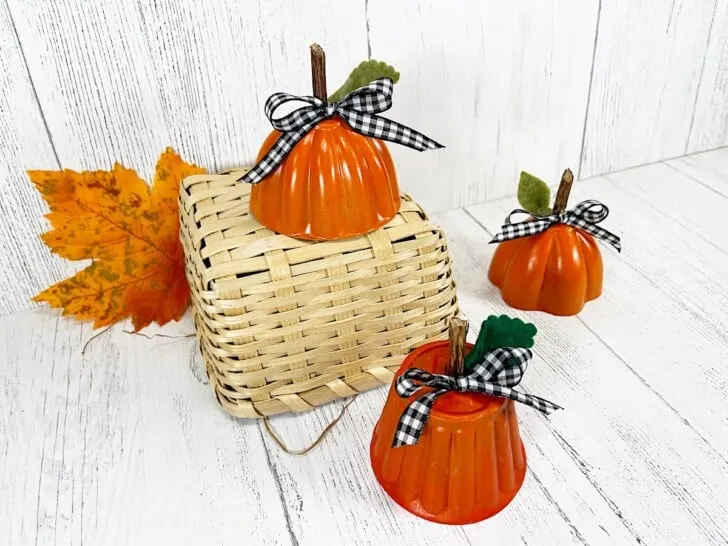 Tin Mold Pumpkins on Straw Basket against white wood wall