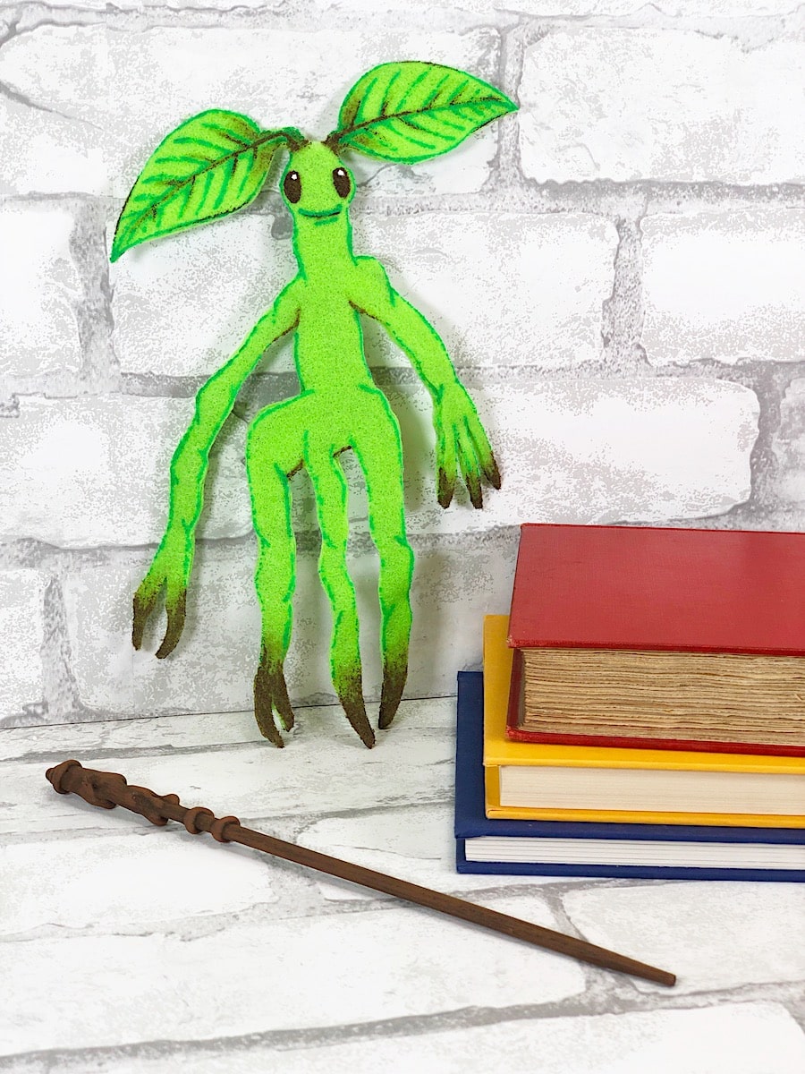 Bowtruckle Craft Against White Brick Wall With Wand and Books