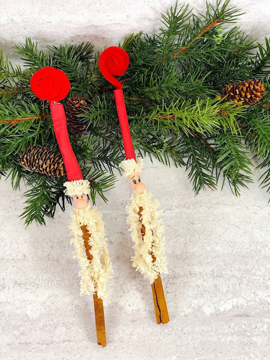 Cinnamon Stick Santa Ornament on White Marble Table With Pine