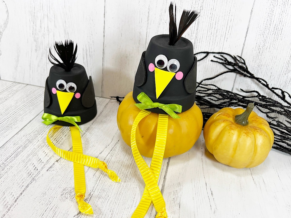 Clay Pot Crows With Pumpkins Against White Wood Wall