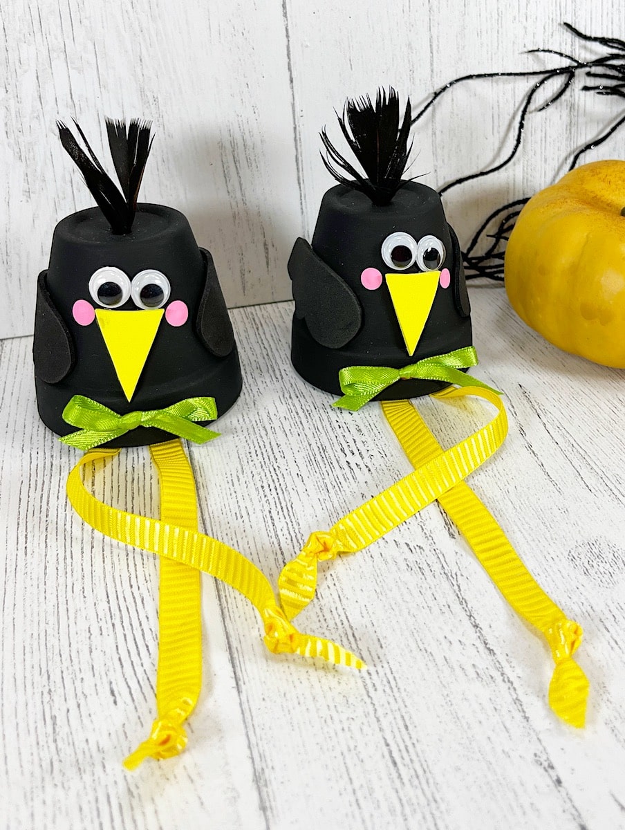 Clay Pot Crows With Yellow Ribbon on White Background
