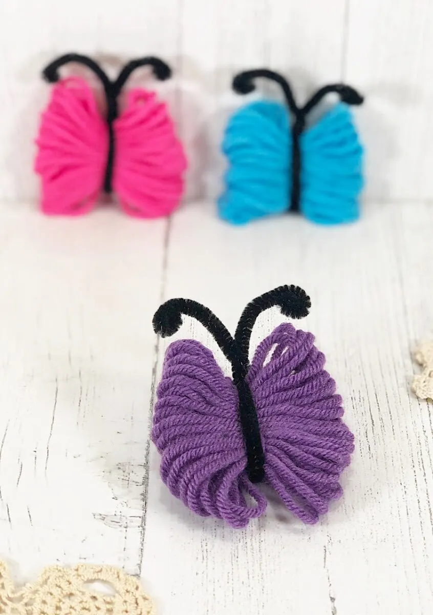 Yarn Butterfly Purple Up Close on White Wood Backdrop