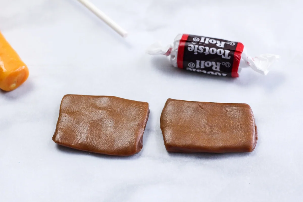 two tootsie rolls flattened into a thin square laying on a marble surface