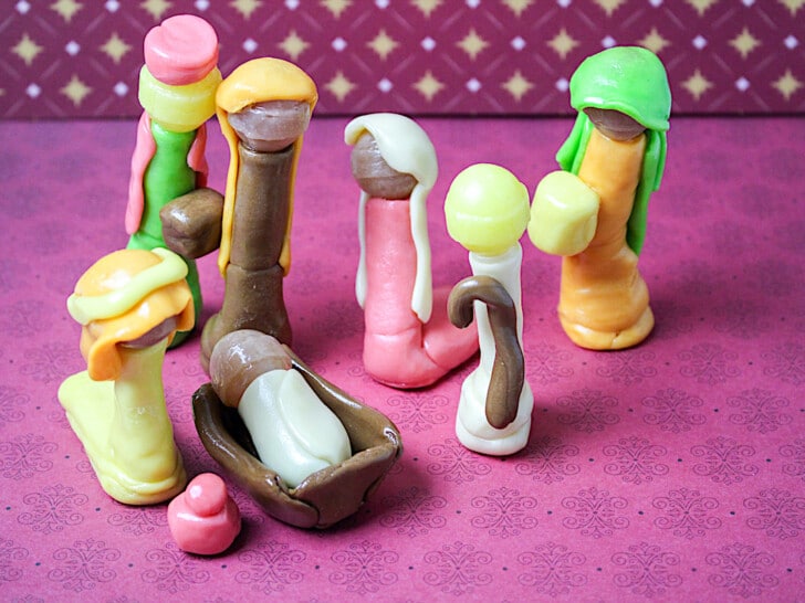 A group of figurines on a pink background.