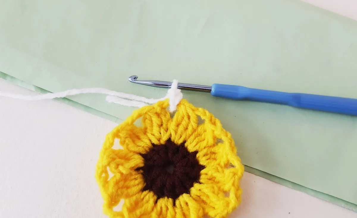 Crochet Sunflower Granny Square Step 18 A crocheted sunflower on a piece of paper.
