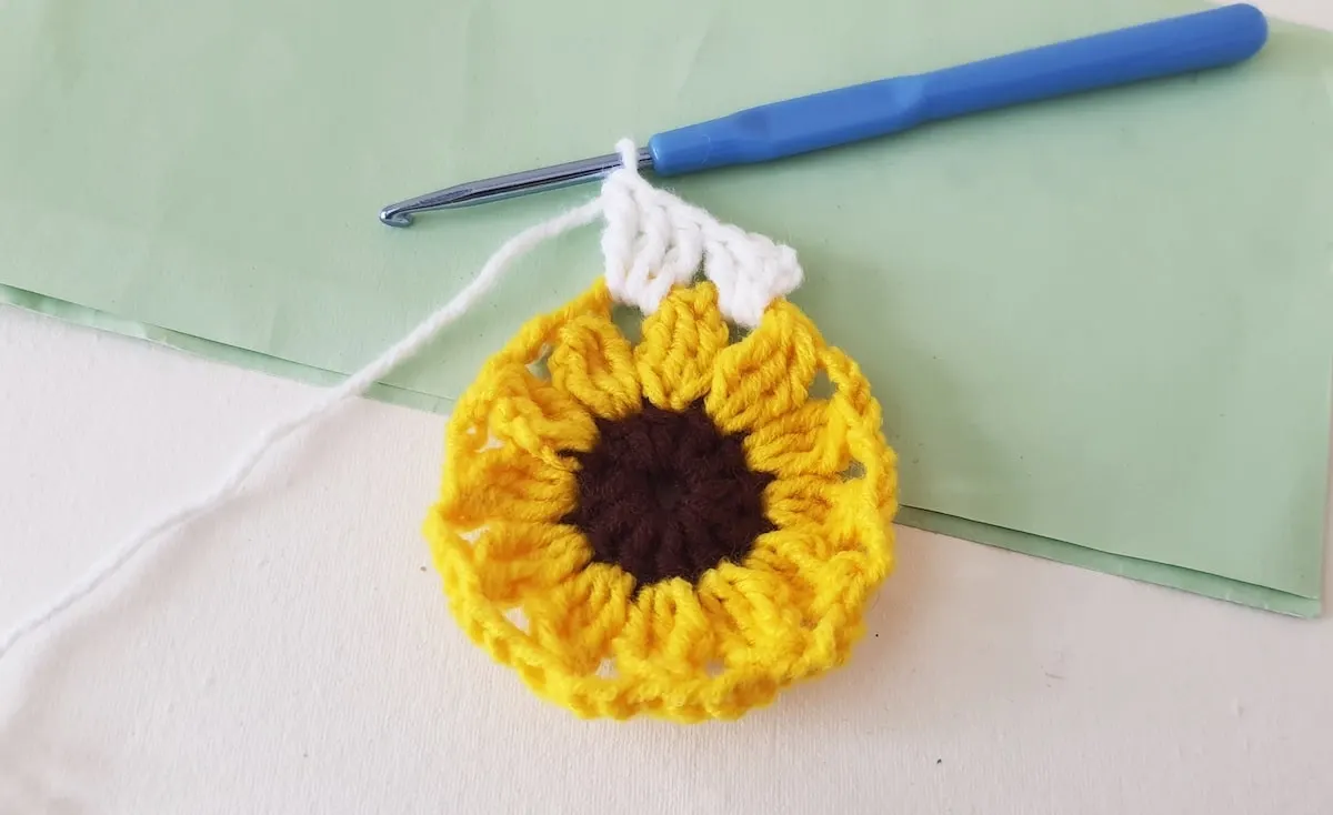 Crochet Sunflower Granny Square Step 20 A crocheted sunflower on a piece of paper.