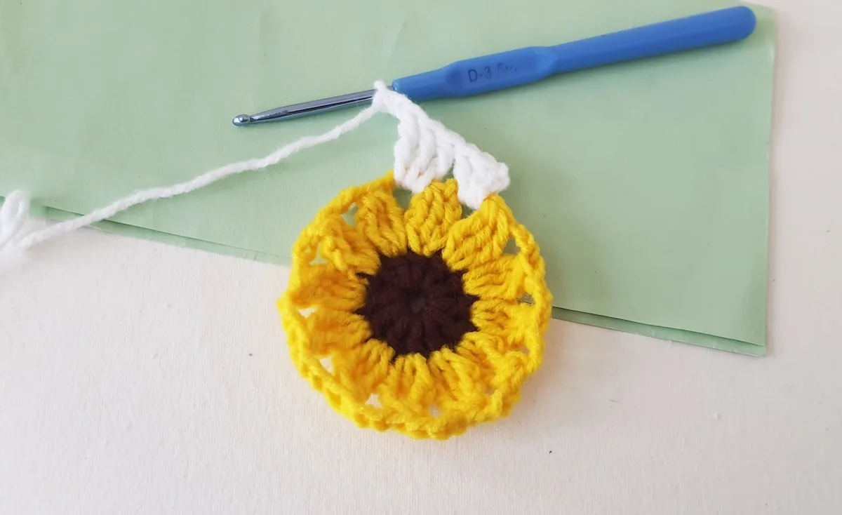 Crochet Sunflower Granny Square Step 21 A crocheted sunflower on a piece of paper.