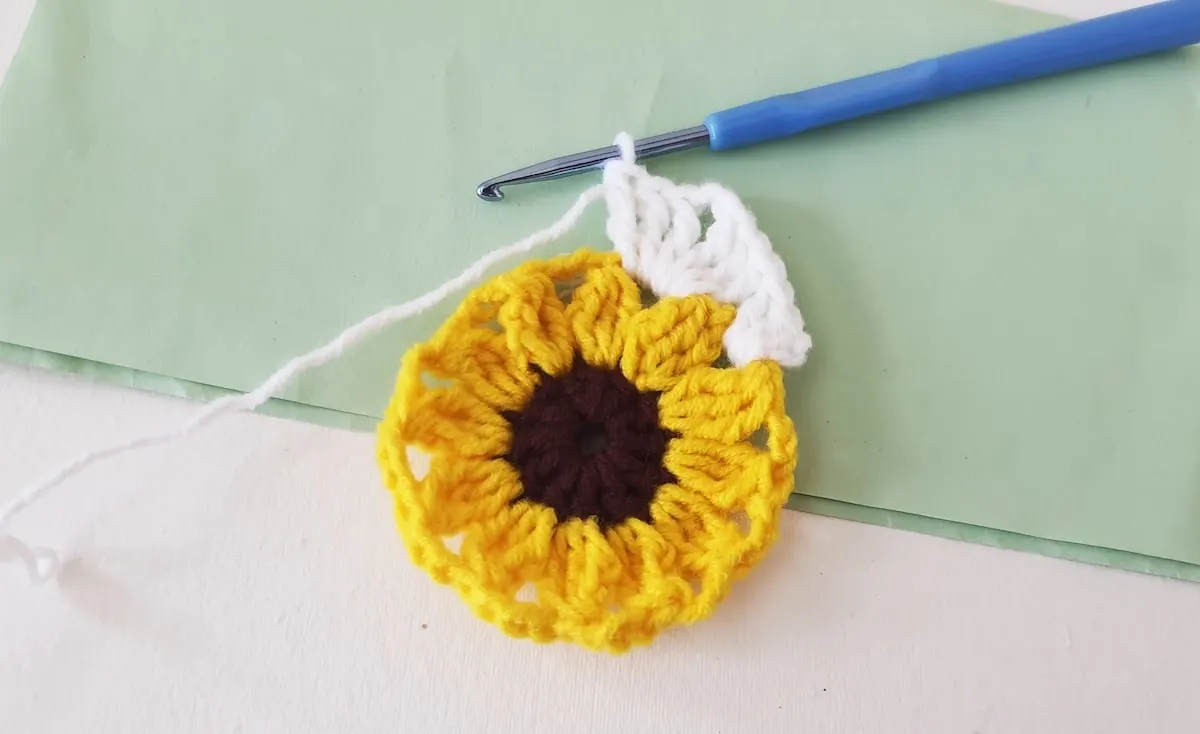 Crochet Sunflower Granny Square Step 22 A crocheted sunflower on a piece of paper.