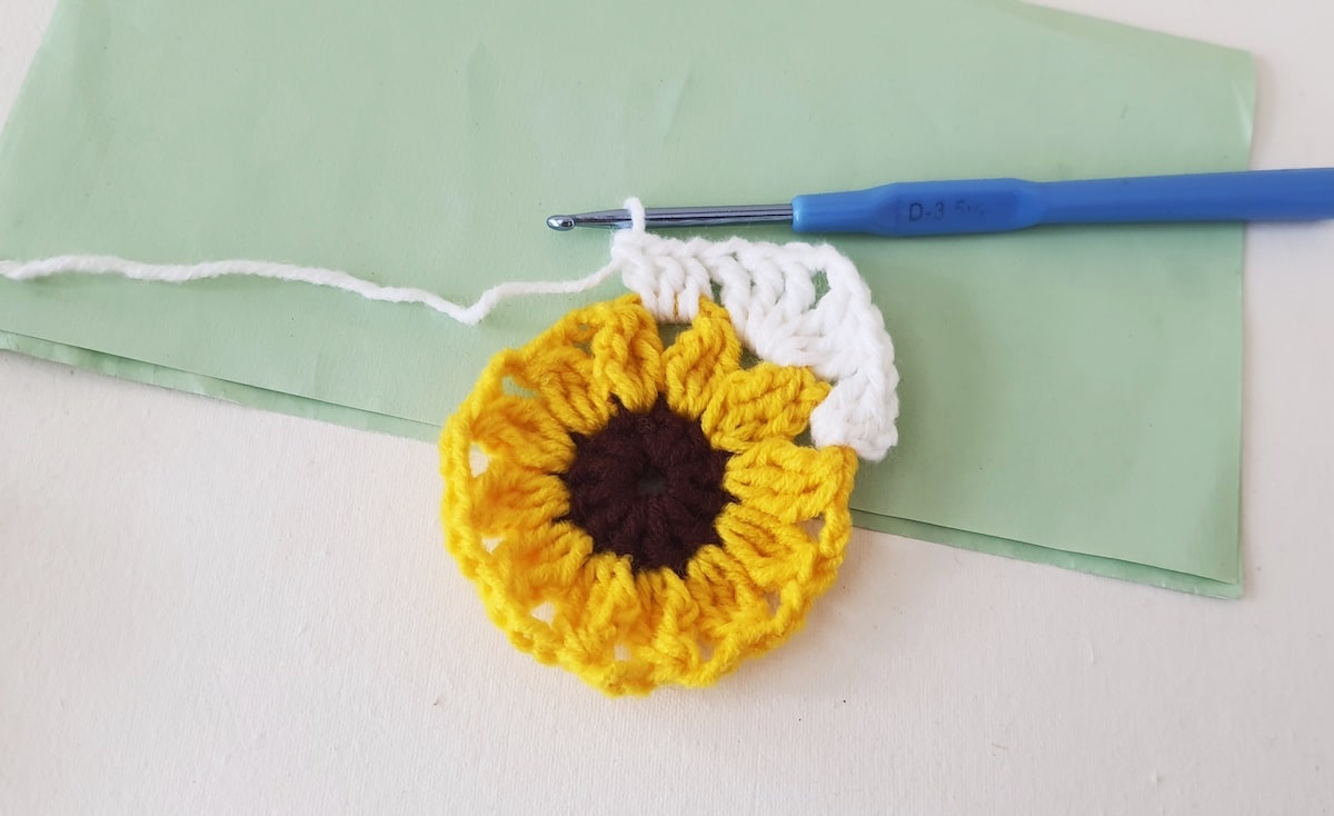 Crochet Sunflower Granny Square Step 23 A crocheted sunflower on a piece of paper.