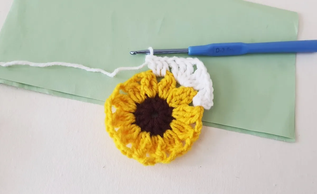 Crochet Sunflower Granny Square Step 23 A crocheted sunflower on a piece of paper.