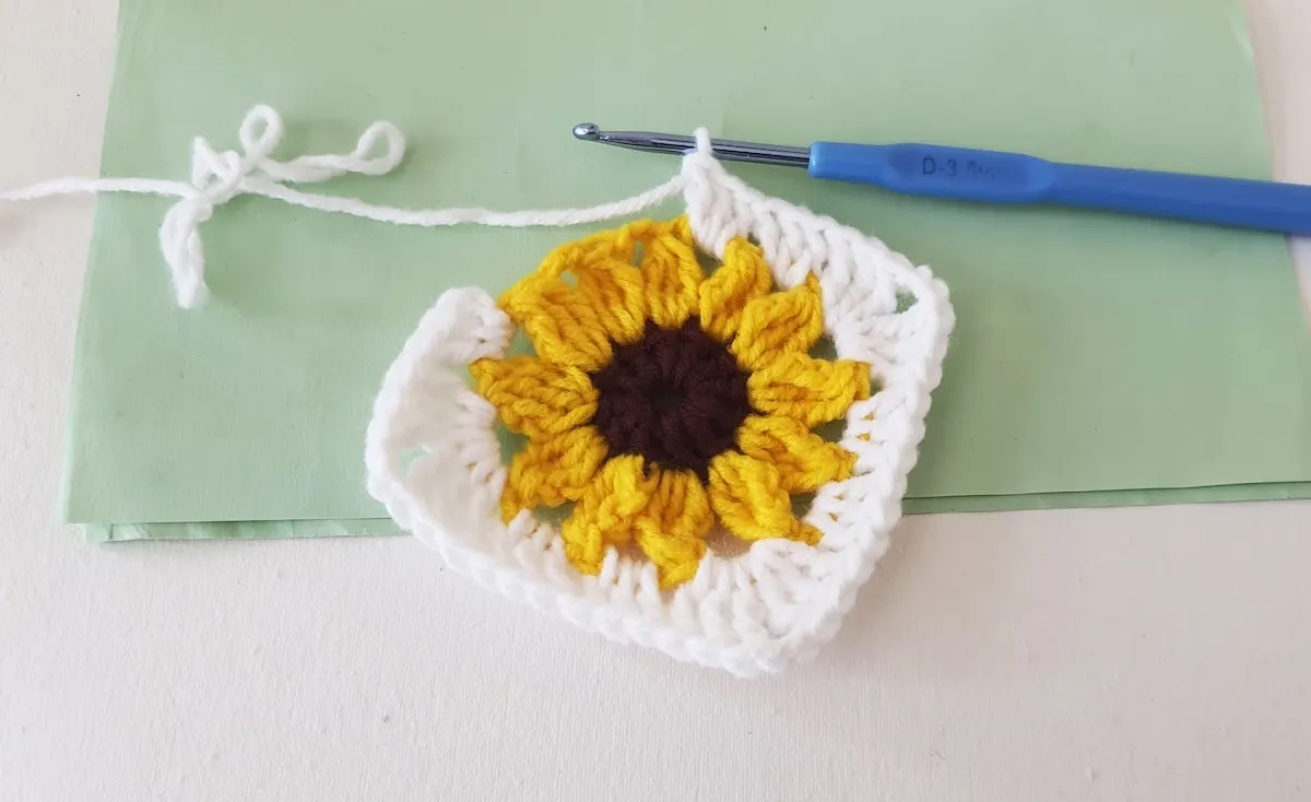 Crochet Sunflower Granny Square Step 24 A crocheted sunflower on a piece of paper.