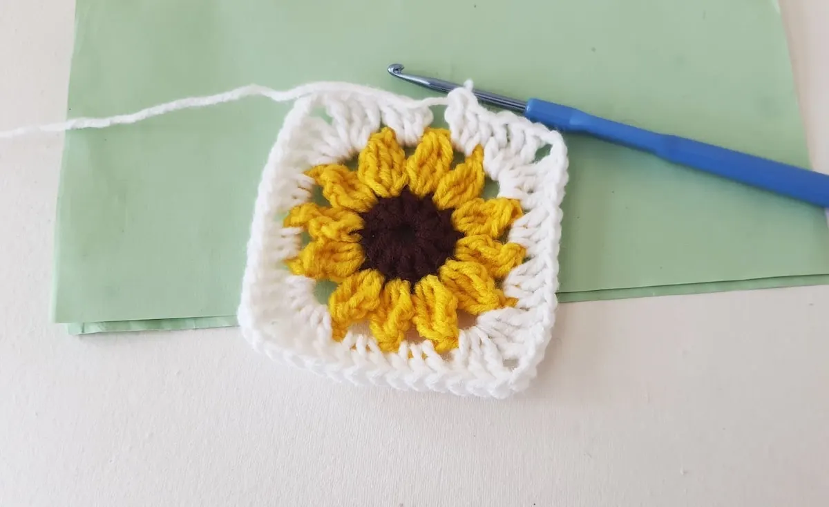 Crochet Sunflower Granny Square Step 25 A crocheted square with a sunflower on it.
