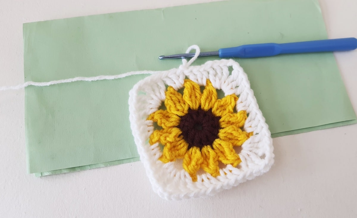 Crochet Sunflower Granny Square Step 26 A crocheted sunflower on a piece of paper.