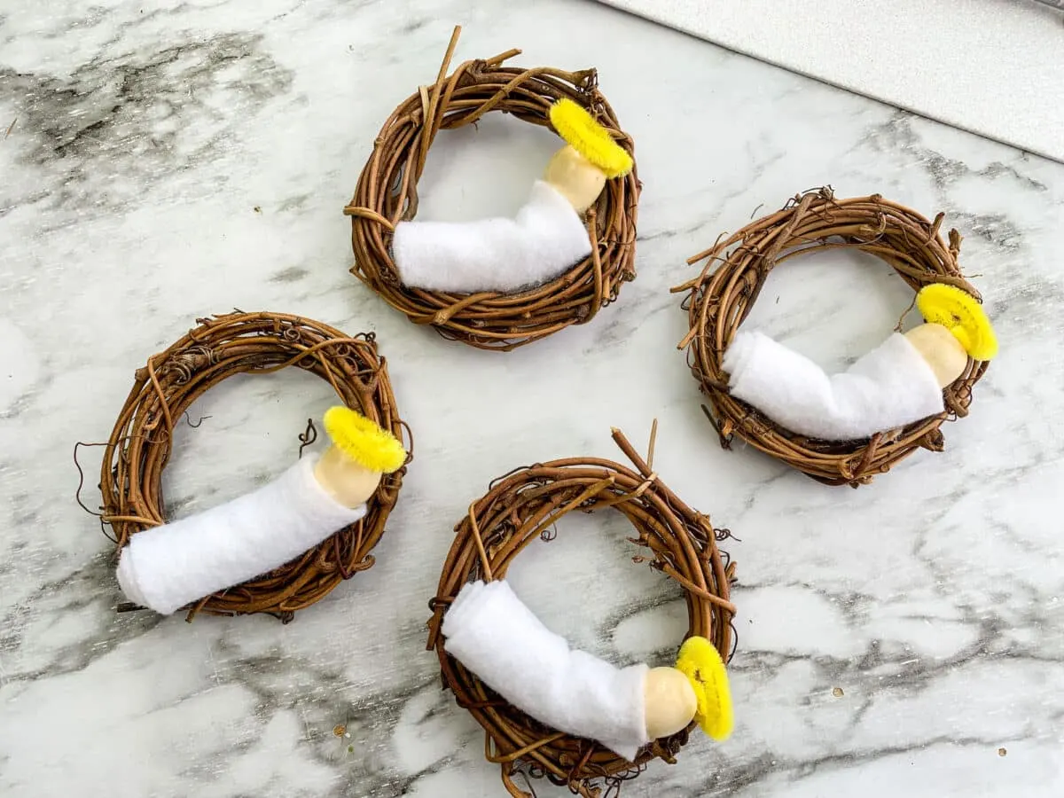 Four baby Jesus nest ornaments on a marble table.