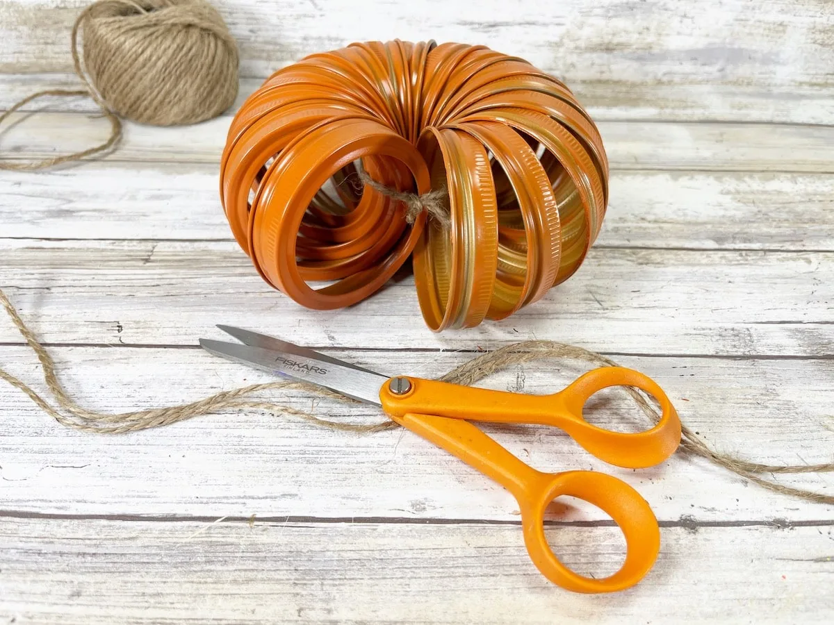 Canning Ring Pumpkin Step 3B with scissors and twine on a white background