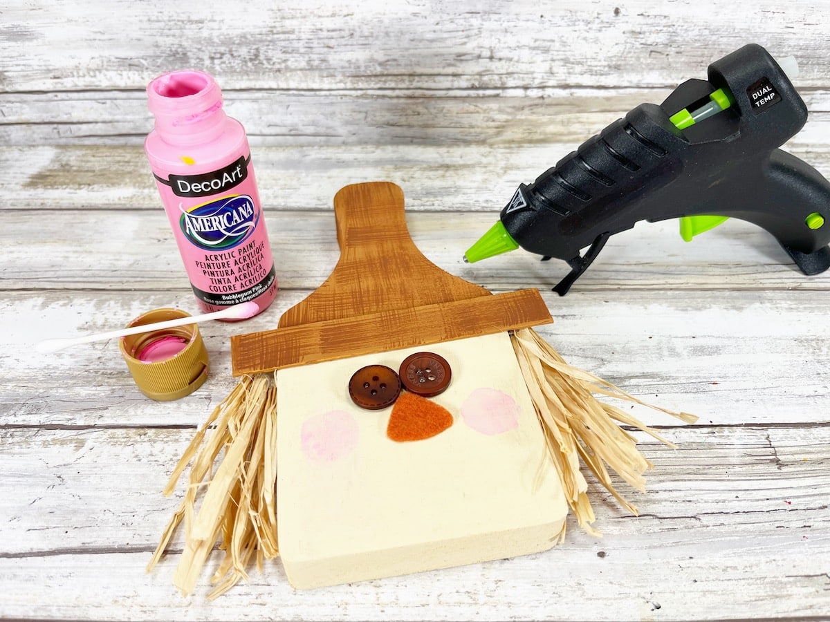 Cutting Board Scarecrow Step 9 with a glue gun and paint.