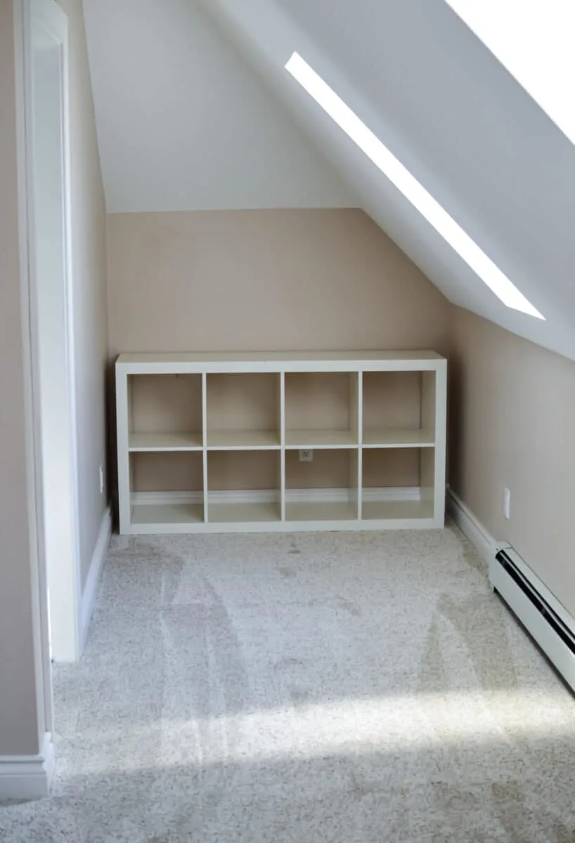 An attic room with a bookcase and a radiator.