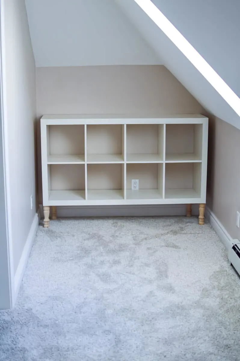 A white bookcase in an attic room.