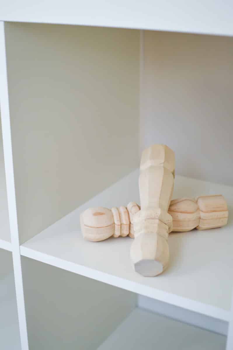 A wooden toy on top of a white shelf.