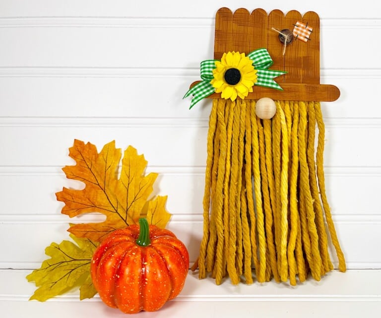 Scarecrow Gnome scarecrow hat with sunflowers and a pumpkin next to it.