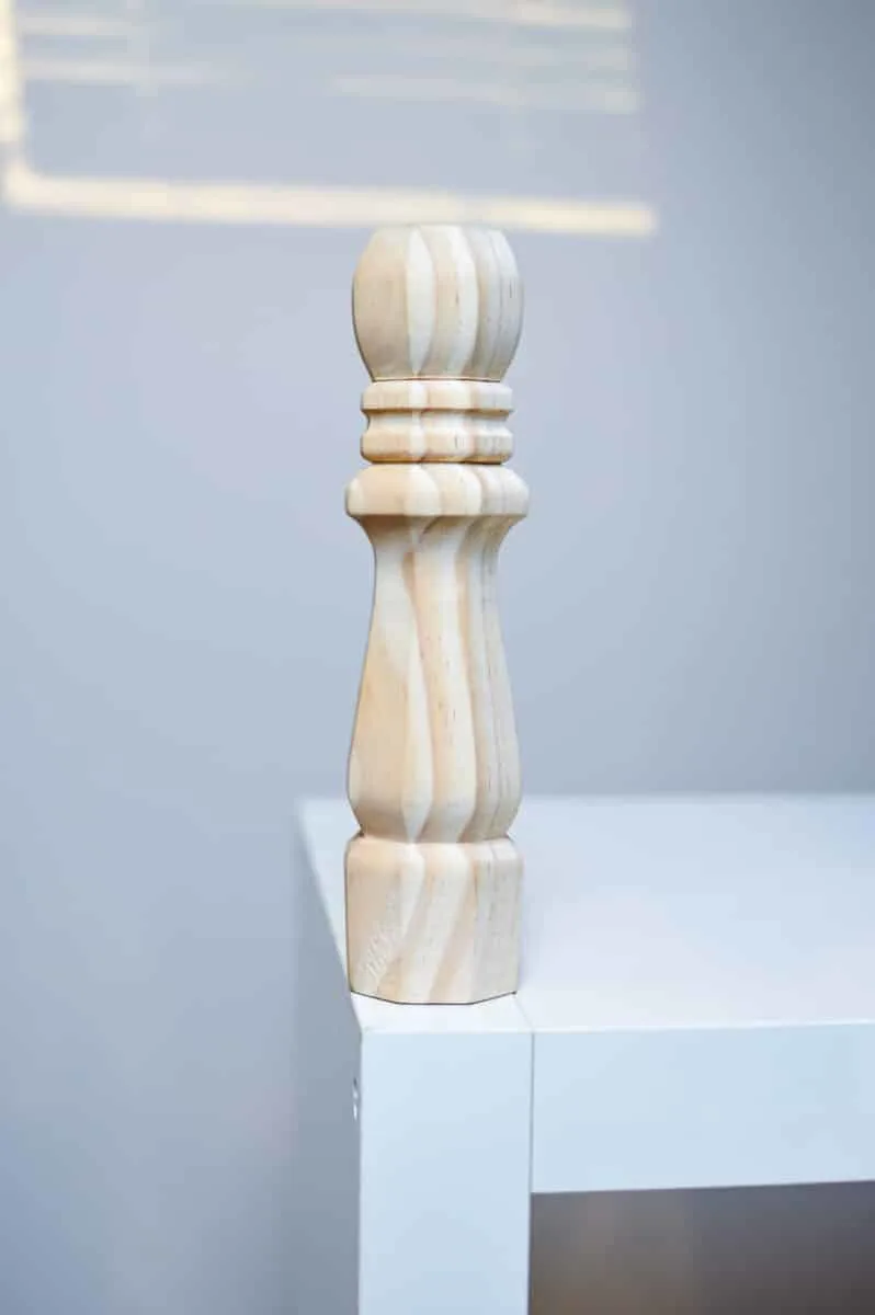 A wooden chess piece on top of a white table.