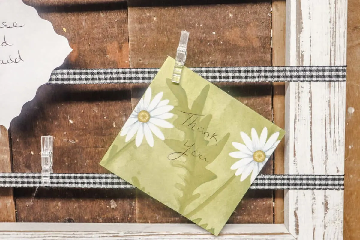 A thank you note is hanging on a wooden board.